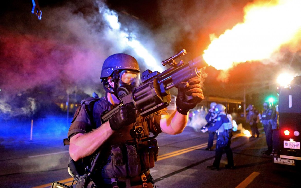 Un policier tire une grenade lacrymogène en direction des manifestants, à Ferguson, le 18 août 2014. 